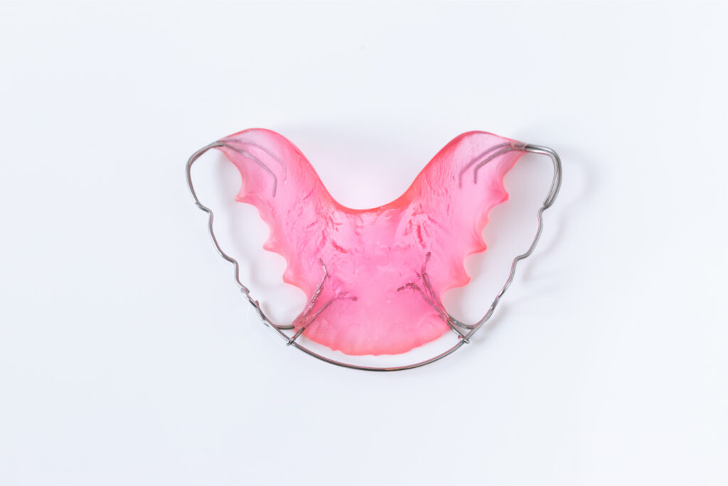 Pink removable retainer for the upper teeth with an acrylic plate and adjustable metal wire